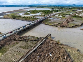 An aerial photo shows a rail bridge (R) damaged and washed away during Cyclone Gabrielle near Napier on February 16, 2023. - New Zealand is under a national state of emergency after Cyclone Gabrielle bore down on its northern coast on February 12.
