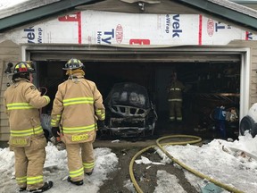Firefighters make quick work of a burning car in a garage in the 4000 block of Carp Road Tuesday.