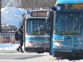 Riders board a Kingston Transit bus at the Cataraqui Centre terminal on Friday.