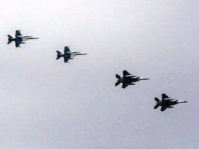 Two RCAF CF-18 Hornet jets, left, and two American F-15 fighter jets fly in formation during Norad training exercises in 2021.