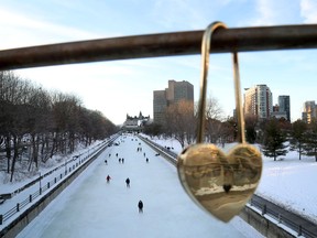 OTTAWA - Feb 3, 2021 - Skaters take to the Rideau Canal Skateway behind one of the "locks of love" placed on the Corktown Bridge on a mild February day in Ottawa on Wednesday. TONY CALDWELL, Postmedia