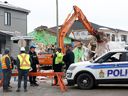 Investigators and the operator of a giant loader sift through the scene of the Orléans explosion on Thursday.