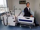 Jayiesh Singh, salah satu pendiri dan CEO dari Able Innovations, berpose untuk foto di Rumah Sakit Saint Vincent dengan peralatan robotiknya yang diciptakan untuk memindahkan pasien dari tempat tidur ke tandu tanpa perlu staf untuk mengambilnya. 