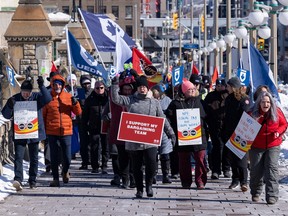 Public Service Alliance of Canada and Union of National Defence Employees members working for the Non-Public Funds march to a rally outside the prime ministers's office in Ottawa on Friday.