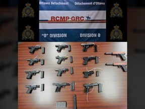 RCMP released this photo of weapons discovered during the search of an Ottawa residence, including 12 illegal handguns, several prohibited high-capacity magazines, ammunition and a device used to convert semi-automatic pistols to automatic.