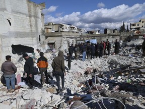 People search through the rubble of collapsed buildings where a newborn girl was found in the town of Jinderis, Aleppo province, Syria, Tuesday, Feb. 7, 2023. A Toronto woman has been devastated after she lost seven of her loved ones in Syria when a massive earthquake destroyed their apartment building early Monday morning.