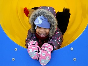 A bit of slippery plastic and a tunnel can add up to a ton of fun as young Enes Mope, 4, and her sister discovered at Winterlude at Jacques-Cartier North Park Thursday.