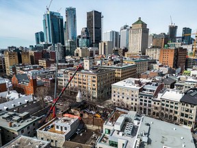 A crane is poised over the Old Montreal fire scene March 26, 2023.