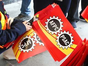 File photo: PSAC members gather signs after a rally in Ottawa, March 27, 2018. Union members will be on strike as of 12:01 a.m. Wednesday, April 19, 2023.