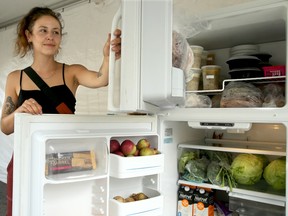 Parkdale Food Centre employee Alexia Smith shows what's inside the new Community Fridge and Pantry outside their centre.
