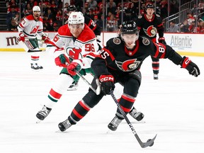 Jake Sanderson (right) of the Ottawa Senators controls the puck as Timo Meier of the New Jersey Devils defends during the second period at Prudential Center on March 25, 2023 in Newark, New Jersey.