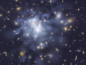 An image from the Hubble telescope shows inferred dark matter in a galactic cluster tinted blue. Scientists have proposed that a second big bang created such exotic matter.