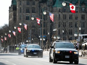 Ontario Provincial Police vehicles speed along Wellington Street in Ottawa as preparations are underway for a visit by U.S. President Joe Biden, Wednesday, March 22, 2023.