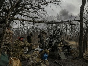 Ukrainian servicemen fire towards Russian positions with a 155mm M777 Howitzer artillery weapon on the front line somewhere near the city of Bakhmut on March 11, 2023 amid the Russian invasion of Ukraine.