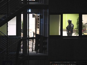 Police officers in special equipment walk through a Jehovah's Witness building in Hamburg, Germany, Thursday, March 9, 2023. German police say shots were fired inside a building used by Jehovah's Witnesses in Hamburg and an unspecified number of people were killed or wounded.