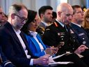 National Defense Minister Anita Anand and Chief of Defense General Wayne Eyre look at their phones during the Ottawa Conference on Defense and Security, in Ottawa, Thursday, March 9, 2023.