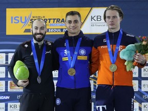 Gold medalist Pietro Sighel of Italy, center, poses with silver medalist Steven Dubois of Canada, left, and bronze medalist Jens van 'T wout, right, of the Netherlands during the award ceremony of the men's 500 meter at at the ISU World Short Track Speed Skating Championships in Seoul, South Korea, Saturday, March 11, 2023.
