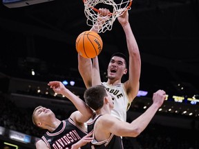 Purdue centre Zach Edey (15) gets a dunk over Davidson forward David Skogman, left, and forward Sean Logan in the first half of an NCAA college basketball game in Indianapolis, Saturday, Dec. 17, 2022.