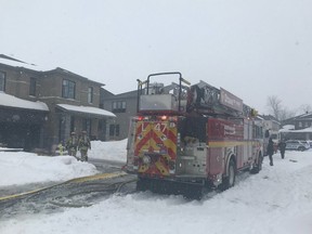 Ottawa firefighters fight a garage fire in the snow in Barrhaven Saturday afternoon.