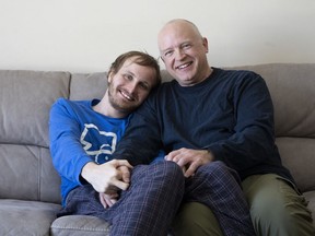 Andrew Kavchak and his son Steven pose for a photo on the sofa in their home in Ottawa, Friday, March 3, 2023.