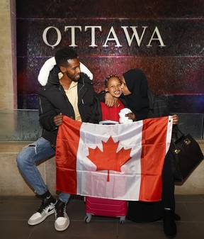 Nasro Adan Mohamed, une réfugiée somalienne basée à Brockville, tente depuis la pré-pandémie de faire venir son mari et sa jeune fille au Canada, mais ils sont bloqués en transit en Ouganda.  Nasro pose pour une photo avec son mari Liiban Ahmed Khadiye et sa fille Afnaan Liiban Ahmed à l'aéroport d'Ottawa mercredi.
