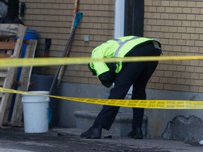 A large Ottawa Police investigation was held at 1883 Walkley Rd. in Ottawa on Wednesday afternoon.  A police officer examines some evidence on Wednesday.