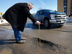 OTTAWA - March 6, 2023 - Bruce Deachman measures  how deep a pot hole is on Richmond Road in Ottawa Monday. Bruce hit this pot hole and got a flat tire. TONY CALDWELL, Postmedia.