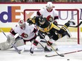 Pittsburgh Penguins' Jason Zucker (16) is checked to the ice by Ottawa Senators' Jakob Chychrun (6) in front of goaltender Dylan Ferguson (34) during the first period of an NHL hockey game in Pittsburgh, Monday, March 20, 2023.