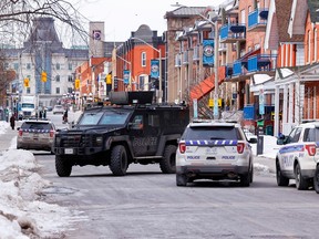 Ottawa Police Service vehicles sit parked outside the building at 312 Cumberland St. on Feb. 21.