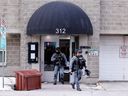 Anggota unit taktis keluar dari pintu depan gedung Perumahan Komunitas Ottawa di 312 Cumberland St. selama respons Layanan Polisi Ottawa di sana pada 21 Februari.