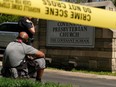 Mario Dennis, one of the kitchen staff at the Covenant School, sits near a police officer after a shooting at the facility in Nashville, Tennessee, U.S. March 27, 2023.