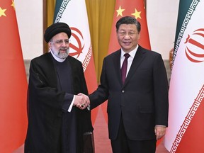 FILE - In this photo released by Xinhua News Agency, Visiting Iranian President Ebrahim Raisi, left, shakes hands with Chinese President Xi Jinping before their meeting at the Great Hall of the People in Beijing, Feb. 14, 2023.