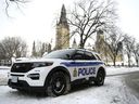 An Ottawa Police officer sits in their cruiser on Wellington Street below Parliament Hill in Ottawa, on Friday, Jan. 27, 2023. What was supposed to be a friendly Friday night charity hockey game between the Ottawa Police Service and the Ottawa Fire Service has ended in controversy over the jerseys worn by the force.THE CANADIAN PRESS/Justin Tang