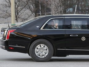 U.S. President Joe Biden gestures from inside his secure vehicle on March 24, 2023.