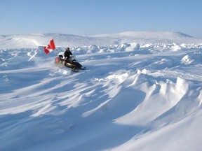 A Canadian Ranger scout looks for an easier route through rough sea ice while on a snowmobile patrol in March 2019.