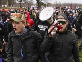 FILE - Proud Boys members Zachary Rehl, left, and Ethan Nordean, walk toward the U.S. Capitol in Washington, in support of President Donald Trump, Jan. 6, 2021. Federal prosecutors disclosed Wednesday, March 22, 2023, that a witness expected to testify for the defense at the seditious conspiracy trial of former Proud Boys leader Enrique Tarrio and four associates was secretly acting as a government informant.