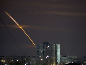 Russian rockets launched against Ukraine from Russia's Belgorod region streak across the sky at dawn in Kharkiv, Ukraine, early Friday, March 24, 2023.