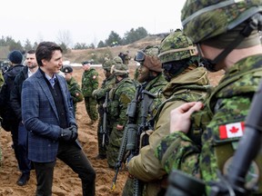 Prime Minister Justin Trudeau talks with Canadian soldiers at a military base northeast of Riga, Latvia last May. He made promises to veterans before the 2015 election that he hasn't kept.