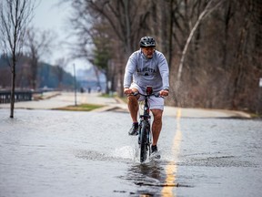 Cyclists pedaled through the Ottawa River water that was flowing over the east end of Rue Jacques-Cartier, Saturday, April 22, 2023.
