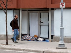A homeless man sleeps on Bank Street. Ottawa can do better for those with no permanent shelter.