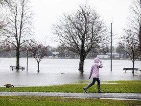 A pedestrian walks thorough flooded Britannia park on the weekend.
