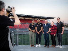 Chris Hofley, OSEG manager of communications, captures a photo of, from left: Redblacks player Nate Behar; Redblacks player Kene Onyeka; Jon Clement, district sales manager for Eastern Ontario with Labatt; Redblacks player Lewis Ward; and Redblacks player Richie Leone.