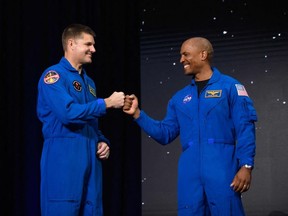 Jeremy Hansen, left, bumps fists with Victor Glover after both were selected for the Artemis 2 mission.