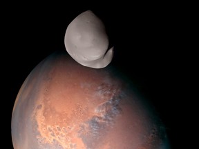 This image released by the Emirates Mars Mission shows Mars' moon Deimos in the foreground.