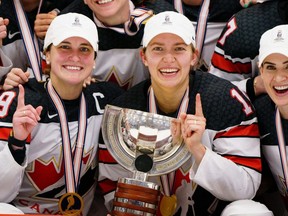 Canada's Marie-Philip Poulin, left, and Brianne Jenner, center, hold the trophy after The IIHF World Championship Woman's ice hockey gold medal match between USA and Canada in Herning, Denmark, Sunday, Sept. 4, 2022.