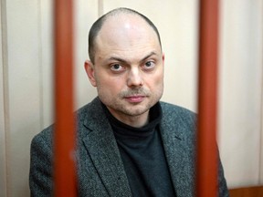 In this file photo taken Oct. 10, 2022, Russian opposition activist Vladimir Kara-Murza sits on a bench inside a defendants' cage during a hearing at the Basmanny court in Moscow. - A Russian prosecutor on April 6, 2023 requested 25 years of imprisonment for Kremlin critic Kara-Murza, who is being tried on several charges including treason for comments critical of the Ukraine offensive, his lawyer said.