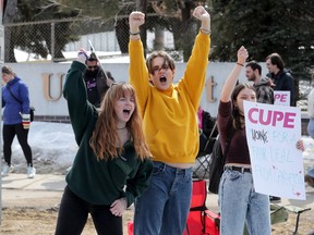 Teaching assistant Niamh Taylor, middle, encourages drivers of vehicles to honk in support of the strike by CUPE Local 4600 at Carleton University in a file photo from late March.