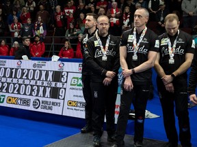 Canadian skip Brad Gushue, vice-skip Mark Nichols, second EJ Harnden and lead Geoff Walker stand on the podium as the scoreboard shows the score in their loss to Team Scotland in the World Men's Curling Championship, Sunday, April 9, 2023 in Ottawa.