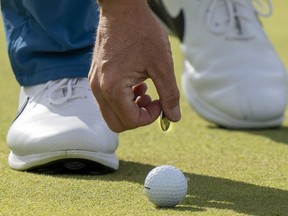 Rory McIlroy marks his ball with a "toonie," a Canadian two-dollar coin, on the 18th green on his way to winning the Canadian Open in Toronto on Sunday, June 12, 2022. Golf Canada is launching a National Golf League for recreational players across the country.