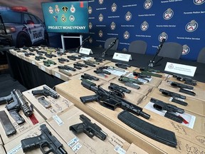 Some the 173 firearms seized in Canada and the U.S. as part of Project Moneypenny are displayed in Toronto on April 11, 2023. Forty-two people were arrested and face 422 criminal charges as part of the year-long cross-border investigation which also nabbed narcotics and cash.